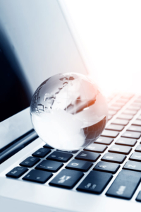 Globus auf Laptop Tastatur - global agierende Unternehmensgruppe dc GmbH